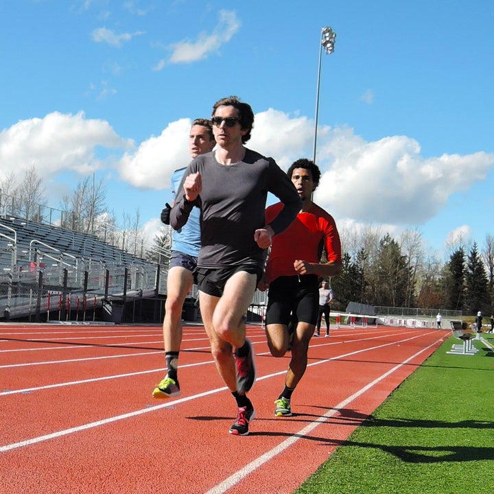young men running intervals on a track