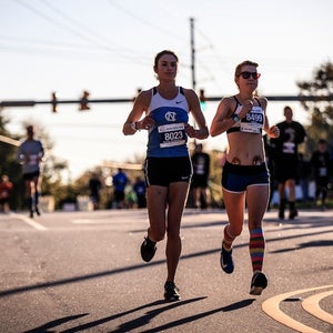 Two women running in a road race.