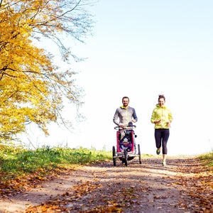 couple running with baby stroller
