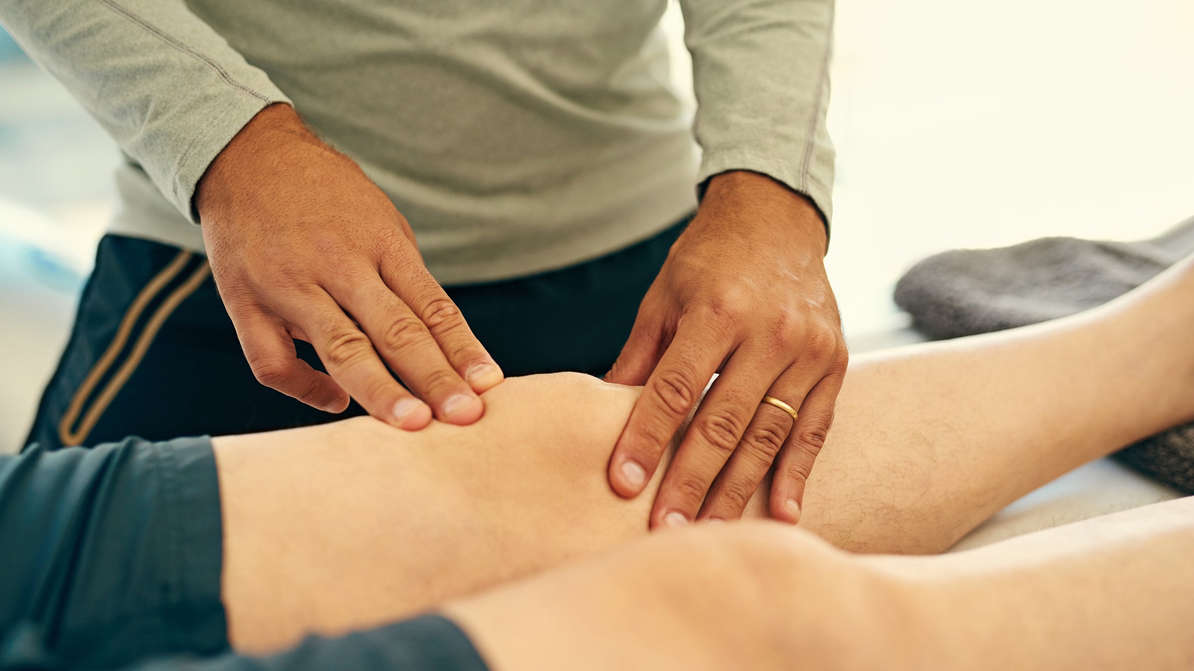 Physical therapist diagnosing knee