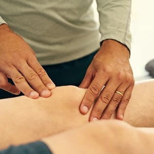 Physical therapist diagnosing knee