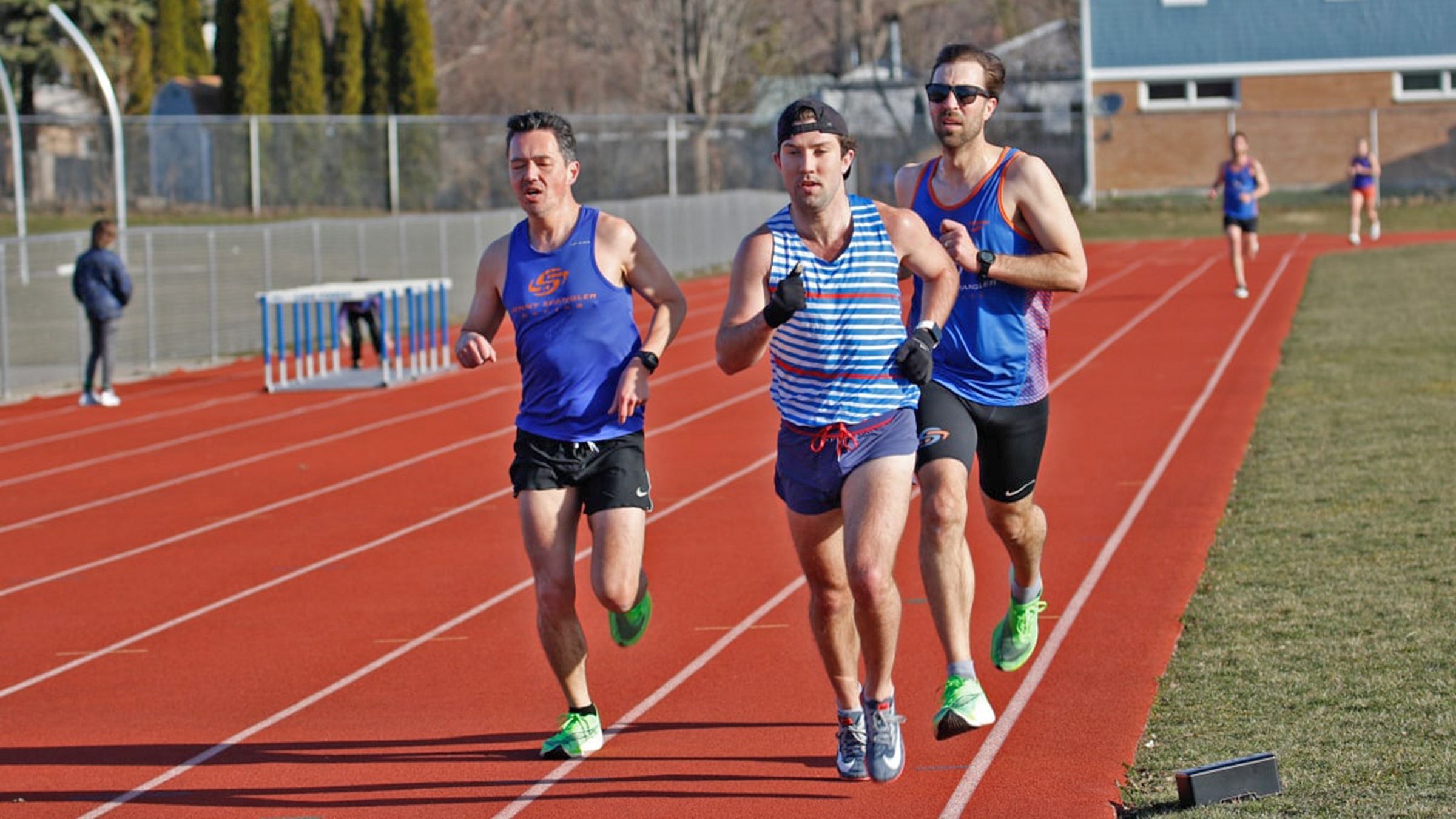 adult runners doing interval workout on track