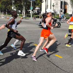 a group of runners on the street running in heat