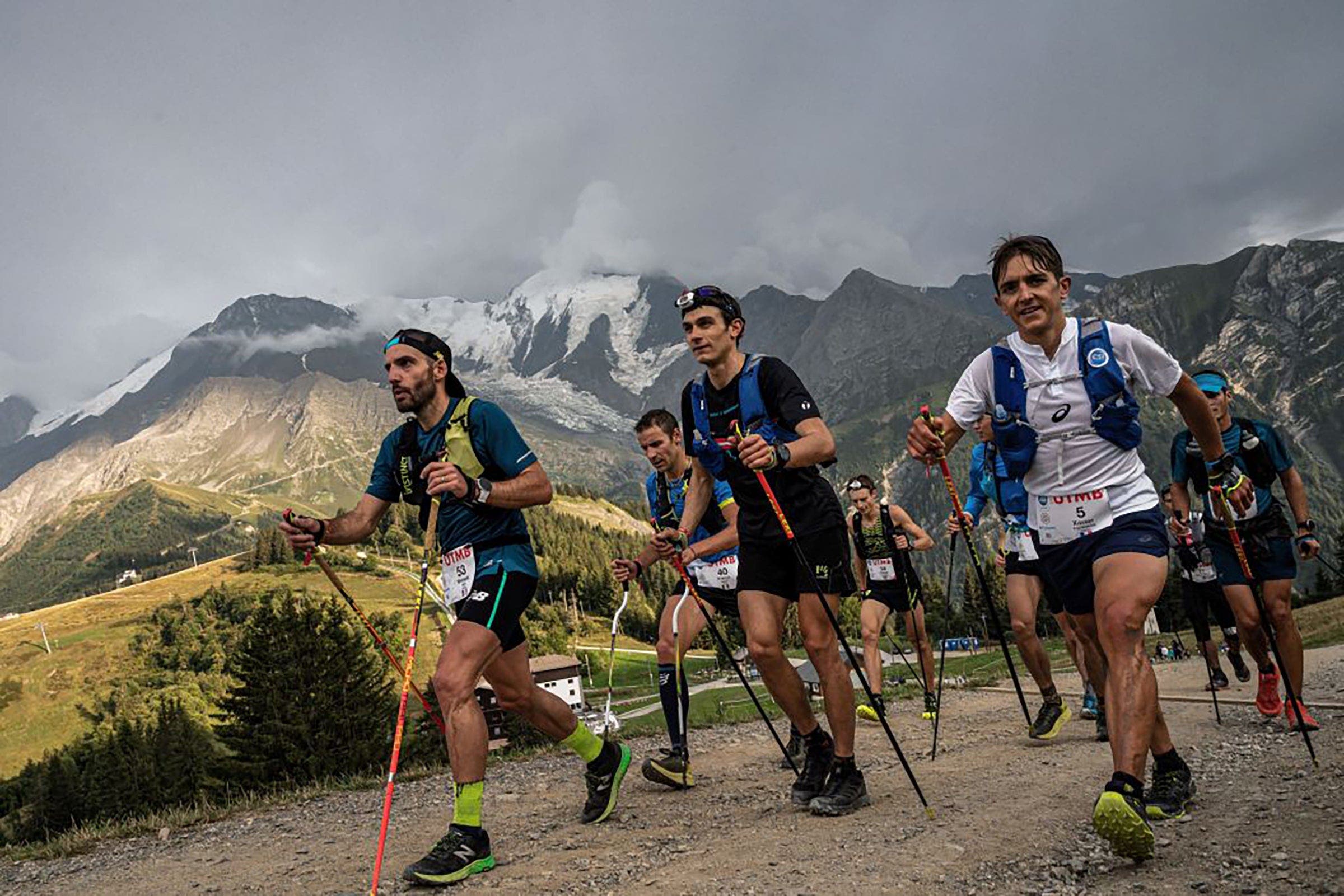 Runners hike with poles during much of the Mont Blanc Ultra Trail (UTMB) race around the Mont-Blanc.