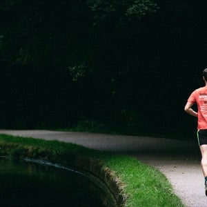 Man running on a paved path in the spring.