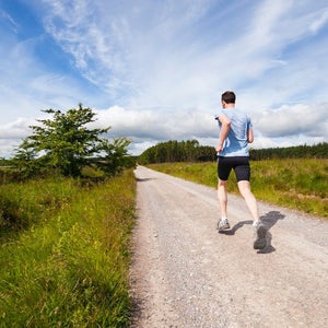 Man running on gravel road.