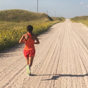 woman running long dirt road