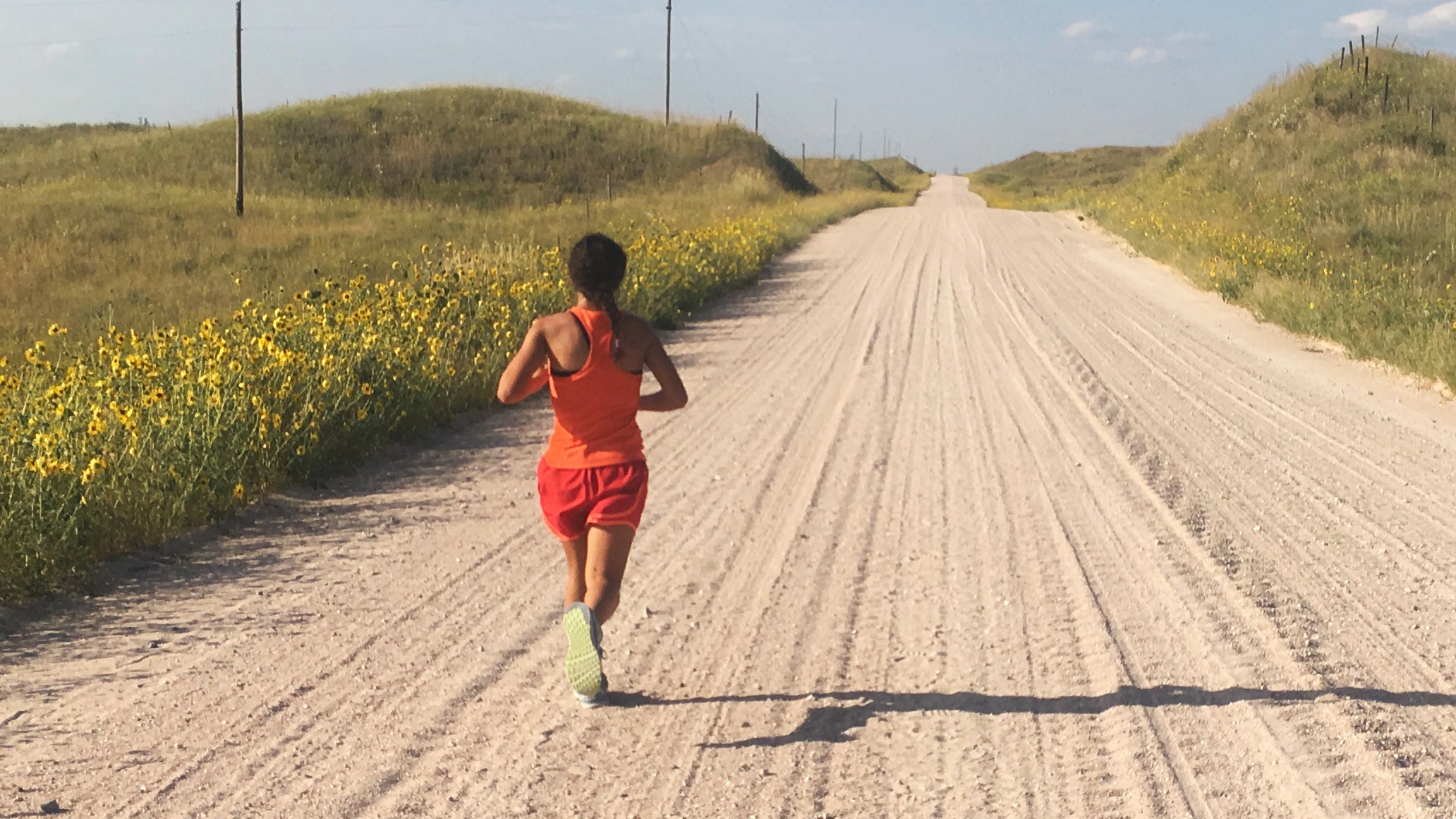 woman running long dirt road