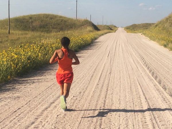 woman running long dirt road