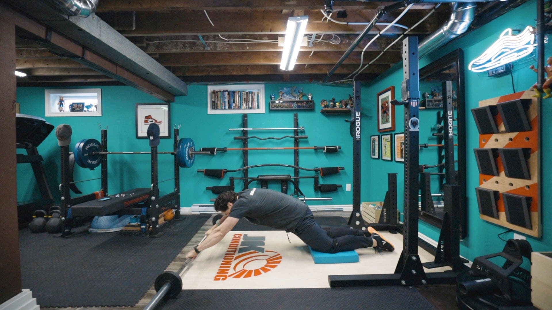 Man on knees with hands on barbell on the ground.