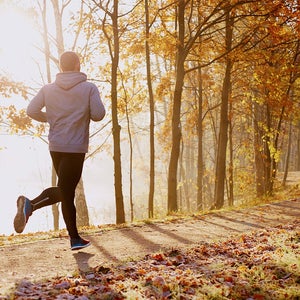 Man running next to lake in the fall