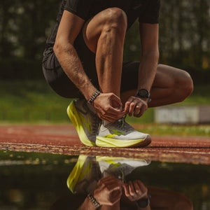 Man lacing up shoe before a run.