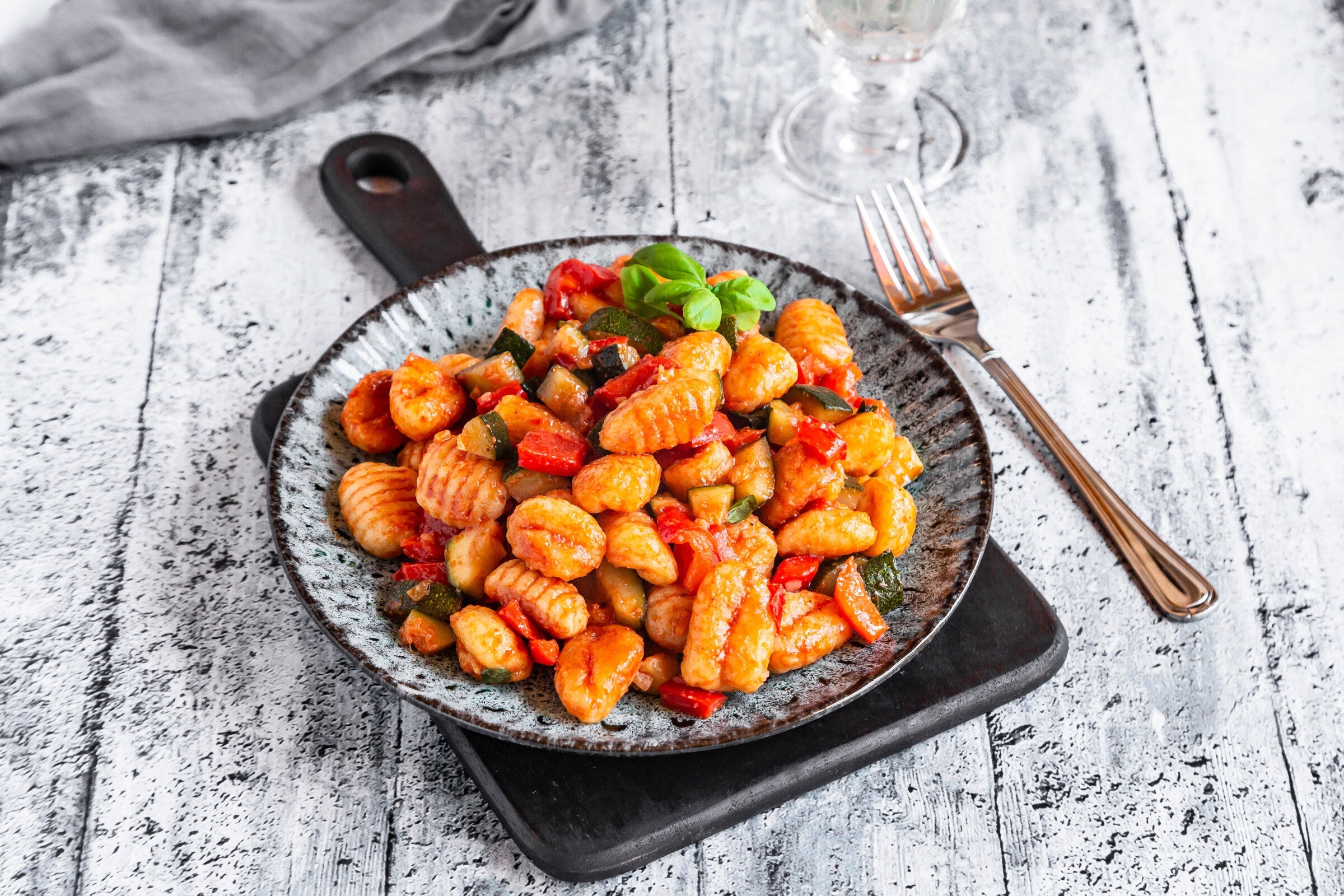 Gnocchi on plate resting on gray wood table