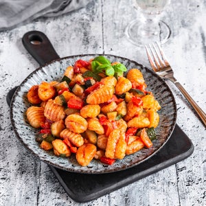 Gnocchi on plate resting on gray wood table
