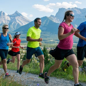 Group of people running by mountains