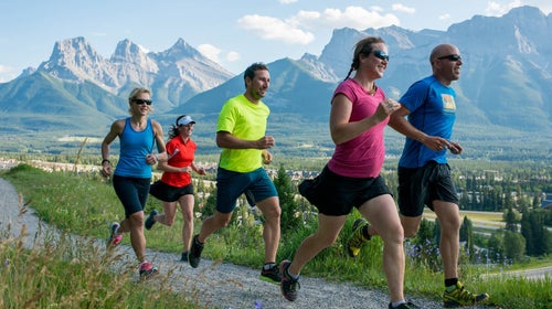 Group of people running by mountains