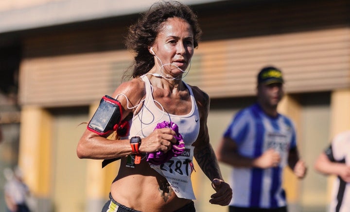 Woman racing a marathon in Spain looking exausted.