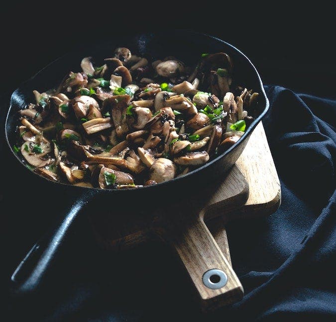 Mushrooms being cooked in pan.