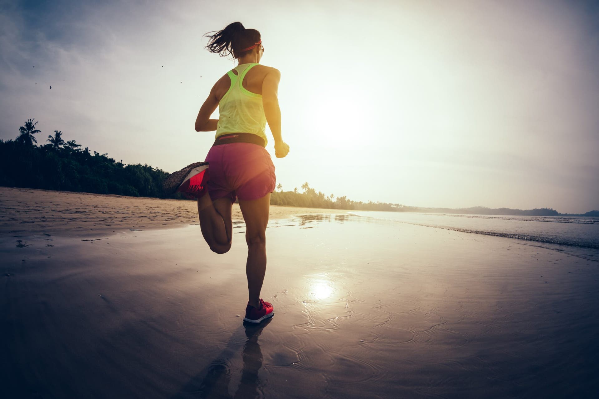 strong woman runner on beach sunset