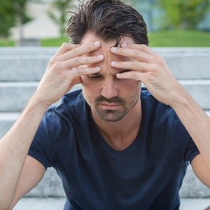 Athlete sitting on stairs with hands on head