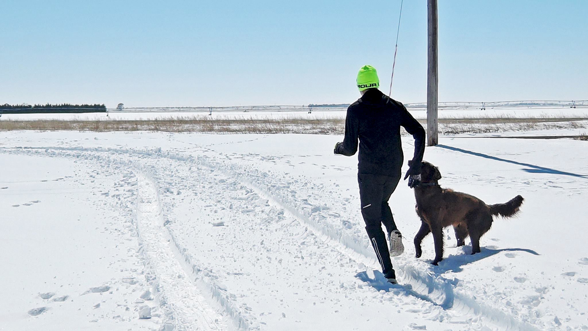 running in the snow with dog