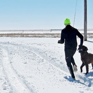 running in the snow with dog