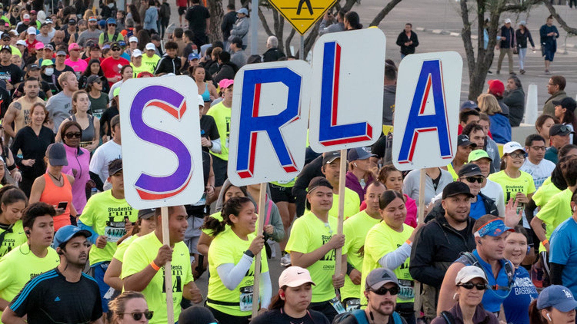 Close-up of SRLA members holding signs that spell SRLA