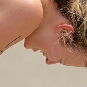 Female athlete bending over in exhaustion after triathlon race