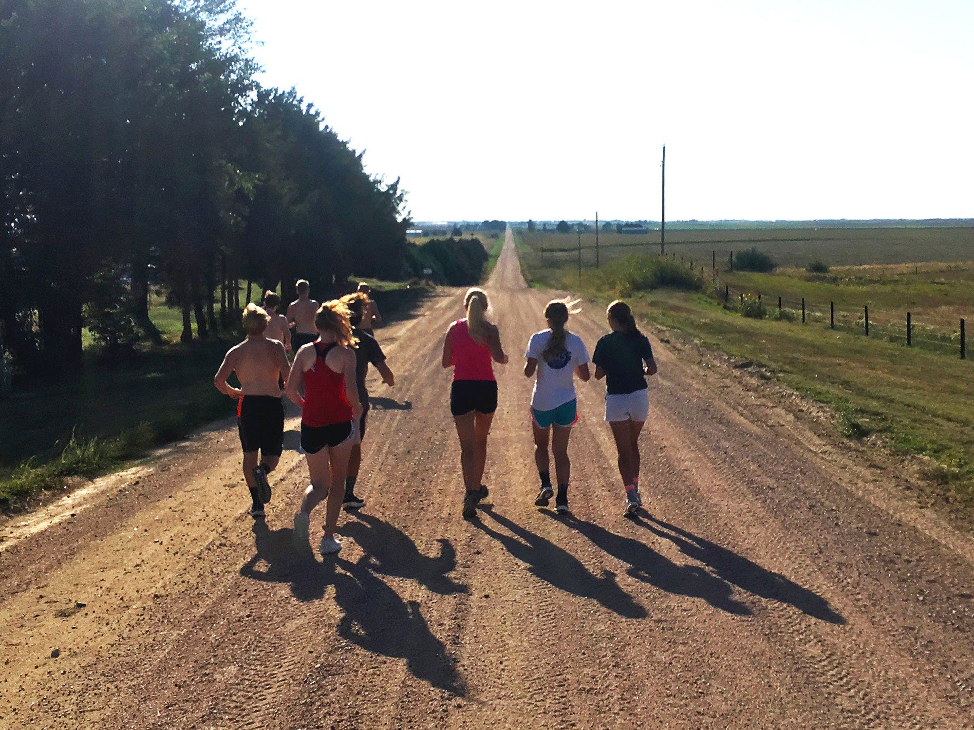 group of young runners hot day dirt road