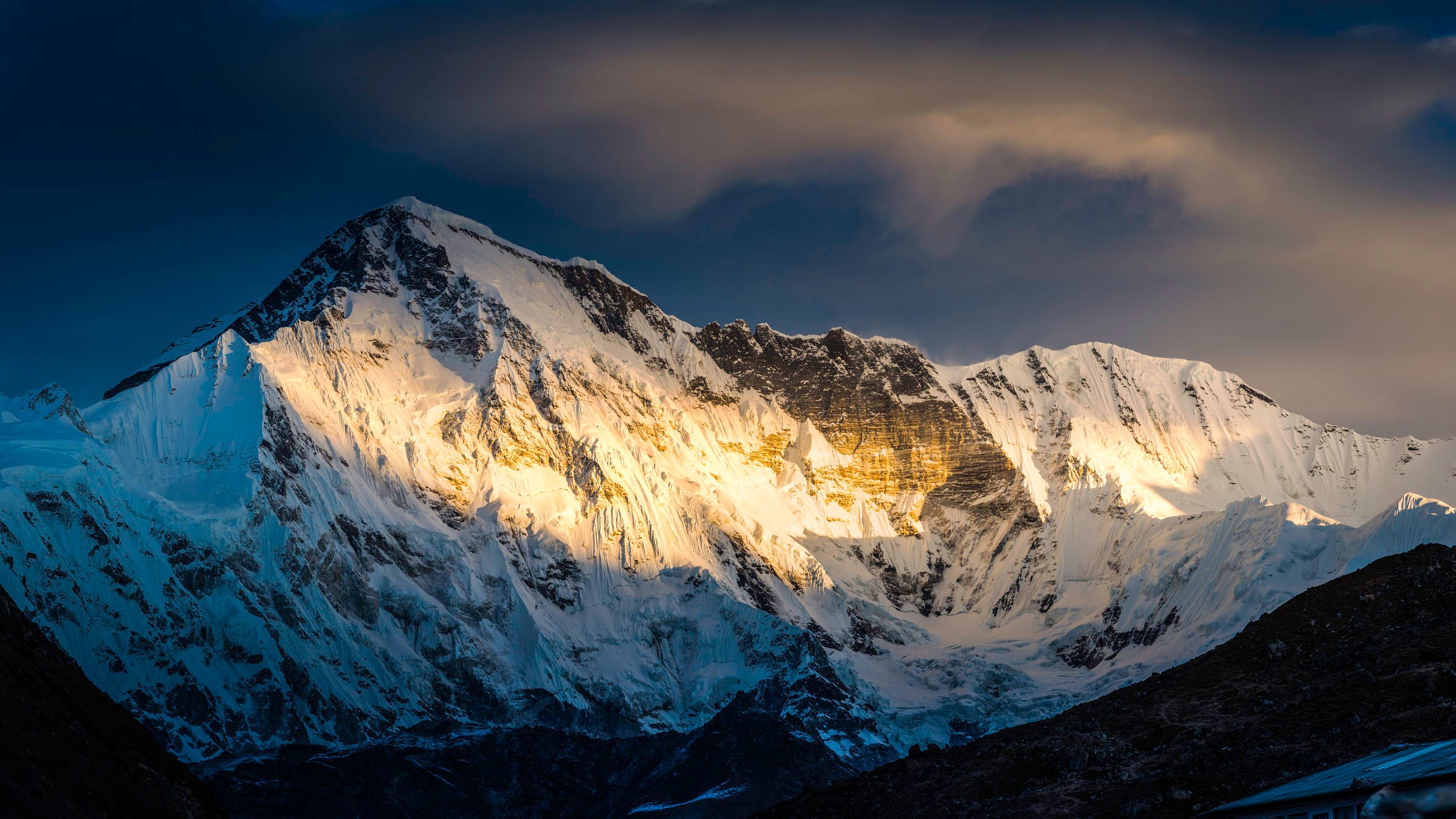 Golden rays of dawn sunlight illuminating the dramatic glaciers and snowy summits of Cho Oyu (8201m) in the Nepal Tibet border deep in the idyllic mountain wilderness of the Everest National Park, a UNESCO World Heritage Site. ProPhoto RGB profile for maximum color fidelity and gamut.