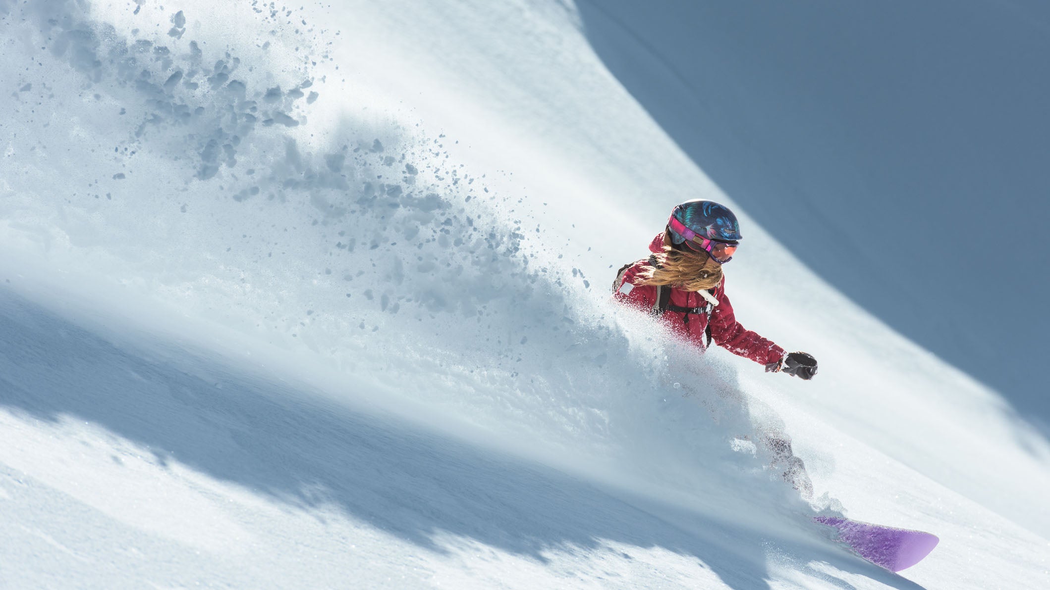 Young Caucasian woman snowboarding in deep  fresh powder snow