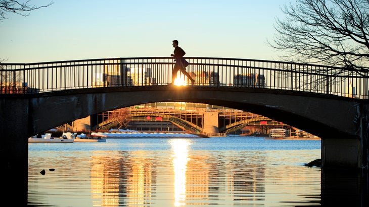 A man runs over a bridge on the Charles River in Boston.