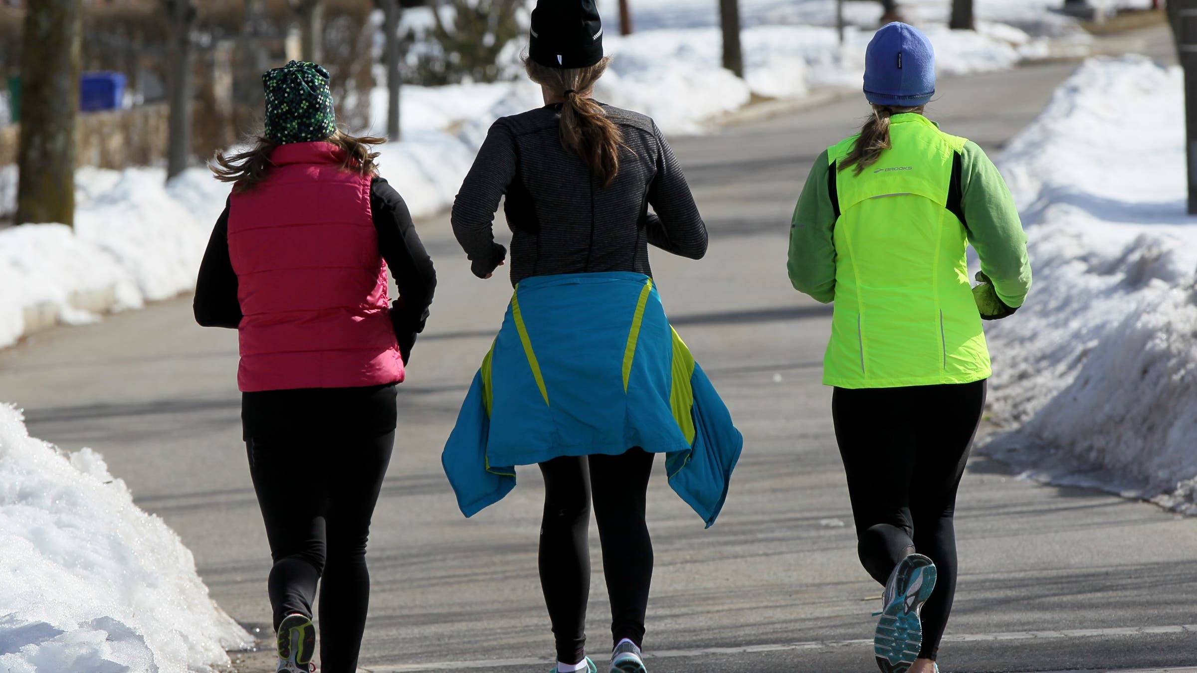 Three women run on the Carriage Road along Commonwealth Ave in Newton.