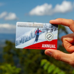 Person holding an 'America the beautiful' annual pass card against vista of Shenandoah