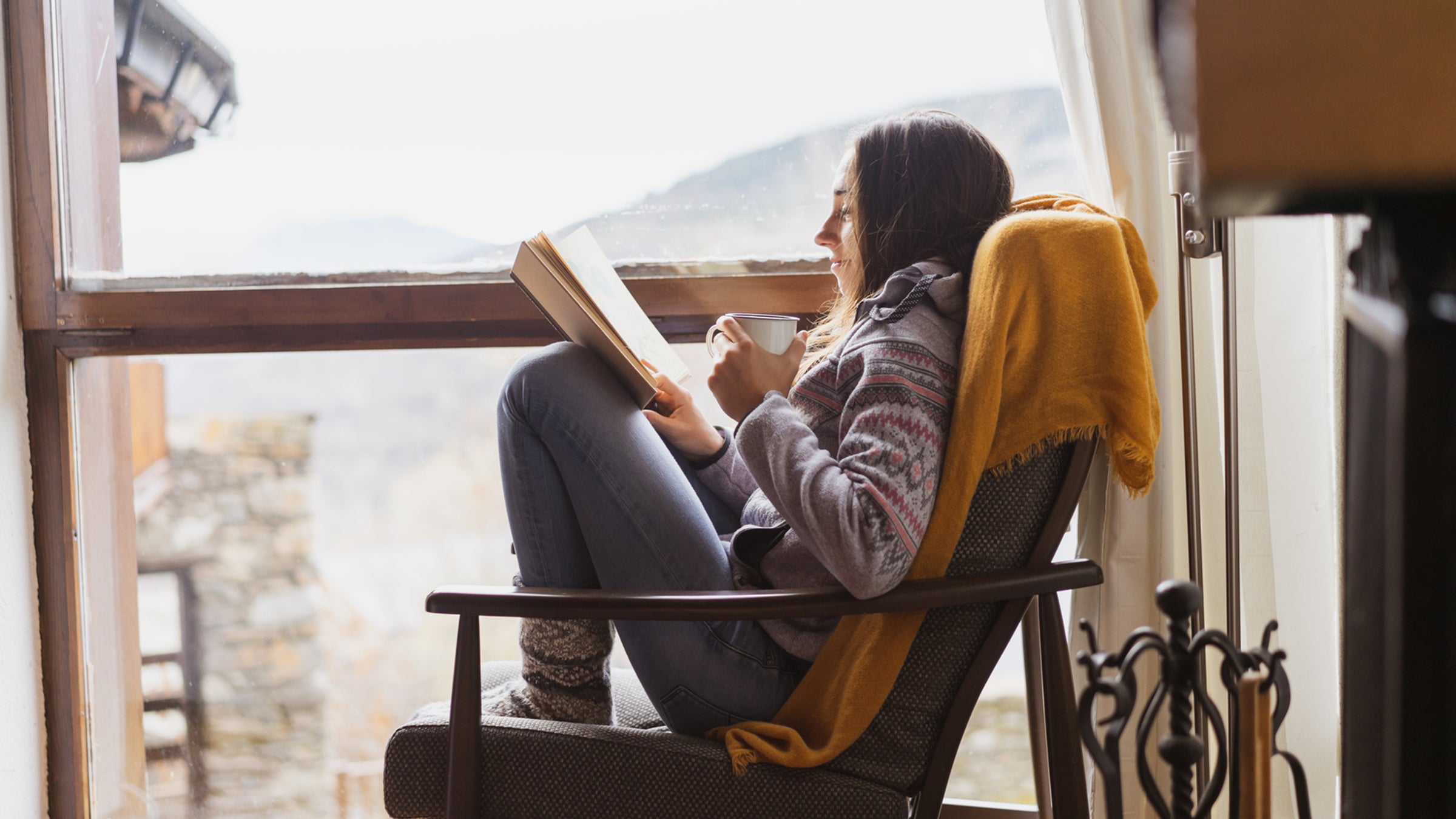 Reading a book by the window in winter