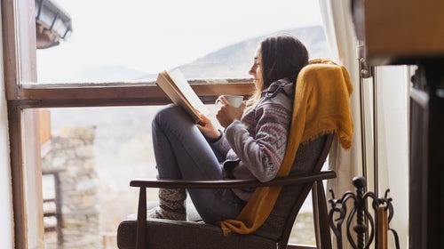 Reading a book by the window in winter