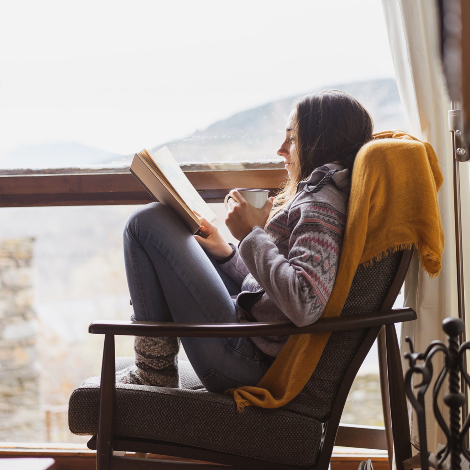 Reading a book by the window in winter