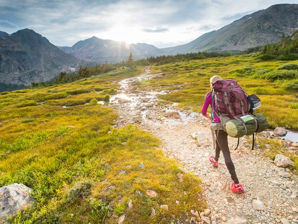 Woman backpacking in the Indian Peaks wilderness on Arapahoe pass trail in Colorado.