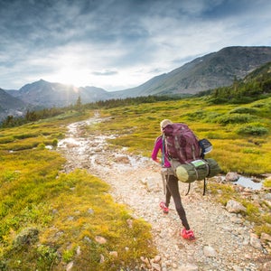 Woman backpacking in the Indian Peaks wilderness on Arapahoe pass trail in Colorado.
