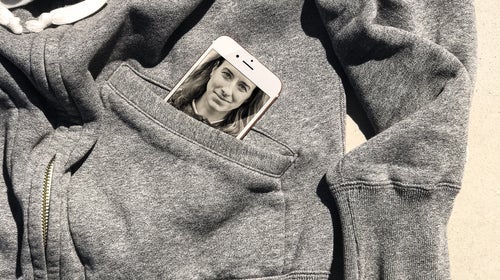 Image of coach on cell phone in sweatshirt pocket