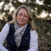 woman in white shirt and vest with blonde hair