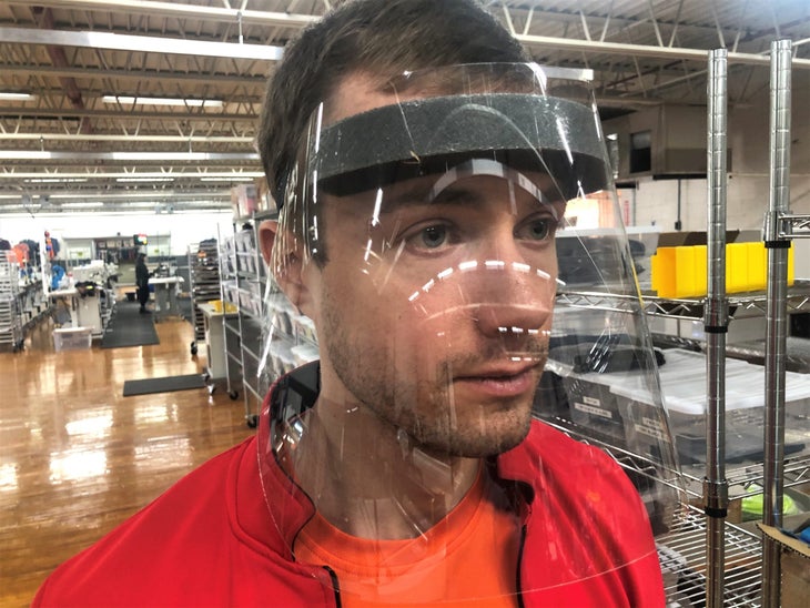 A Kitsbow employee wears a clear plastic face shield.