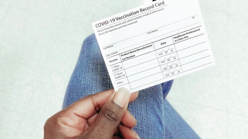Hand holding Covid vaccination card