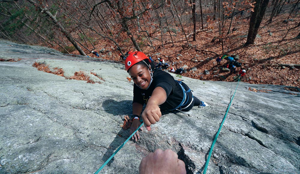 Young girl climbs rocks.