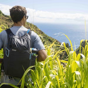 Man wearing backpack looking at the ocean