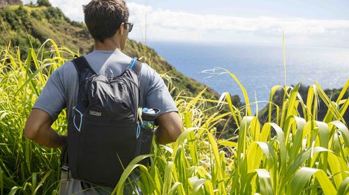 Man wearing backpack looking at the ocean