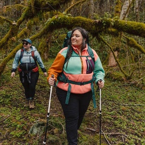 Two people walking through the woods