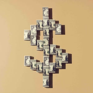 Still life of folded american dollar notes making a shape of the dollar currency sign