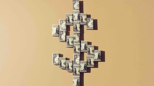 Still life of folded american dollar notes making a shape of the dollar currency sign