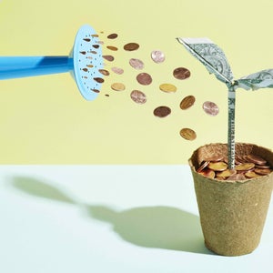 Origami dollar seedling being watered with coins
